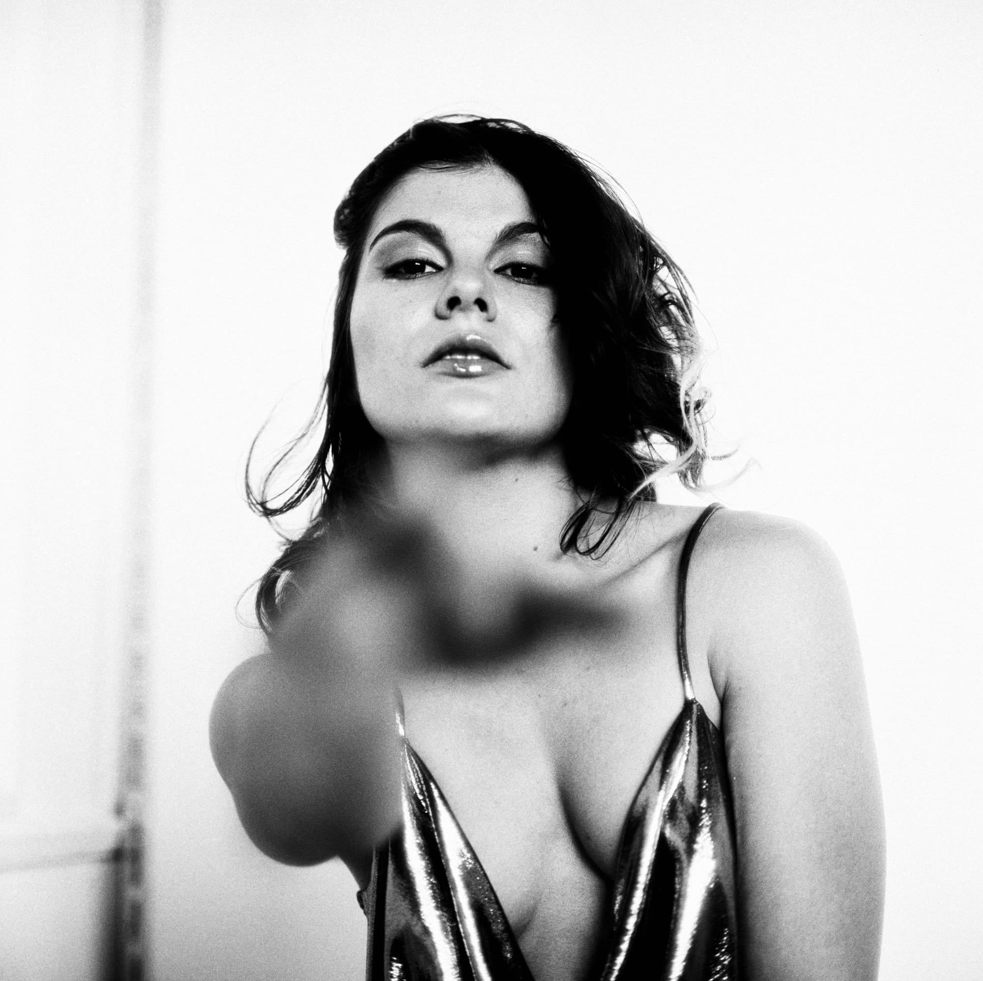 Cinematic black and white portrait of woman reaching out with one hand toward the camera on Foma Ortho 400 film.