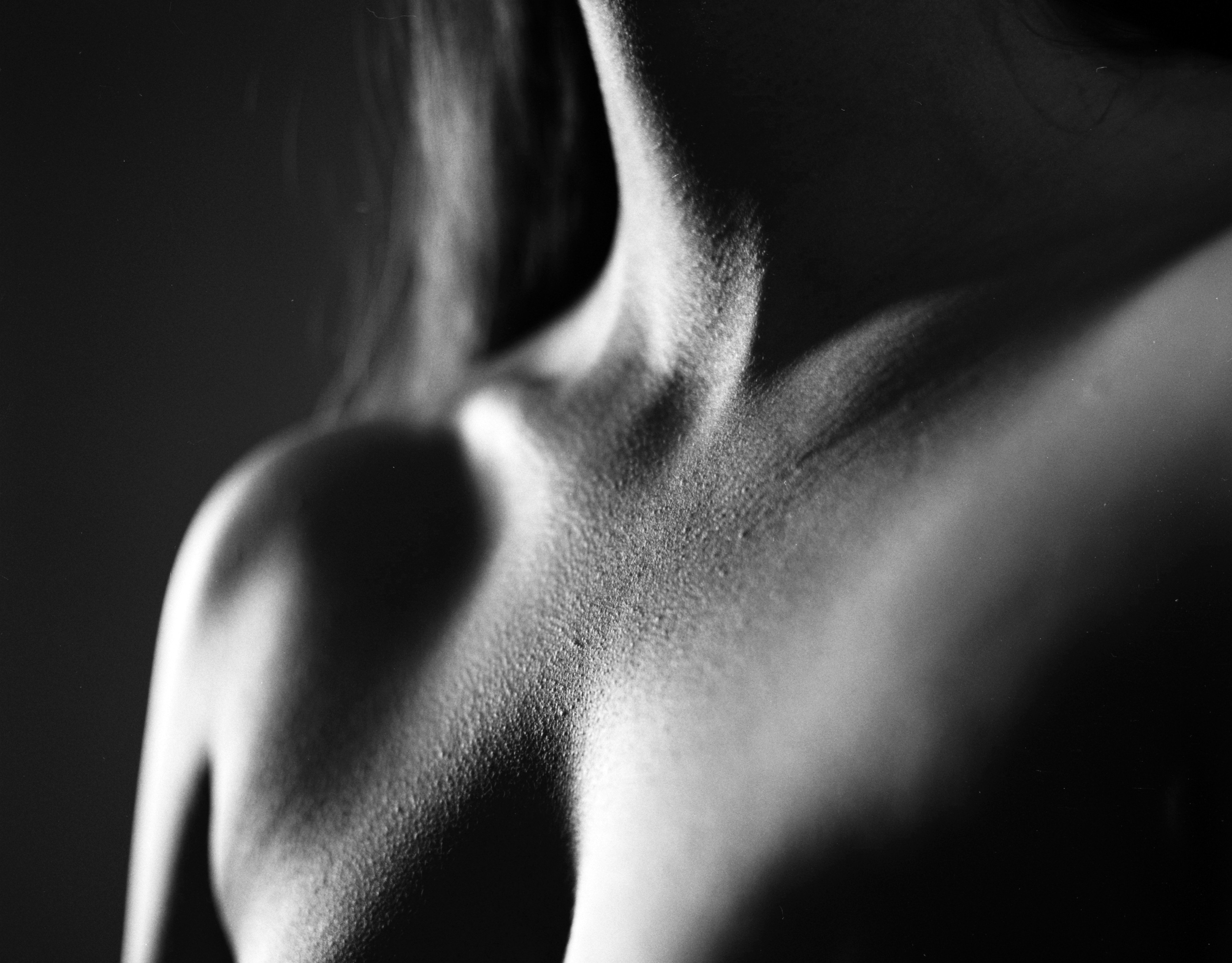 Black and white close-up of a woman neck and chest with goosebumps on Ilford HP5 Plus film.