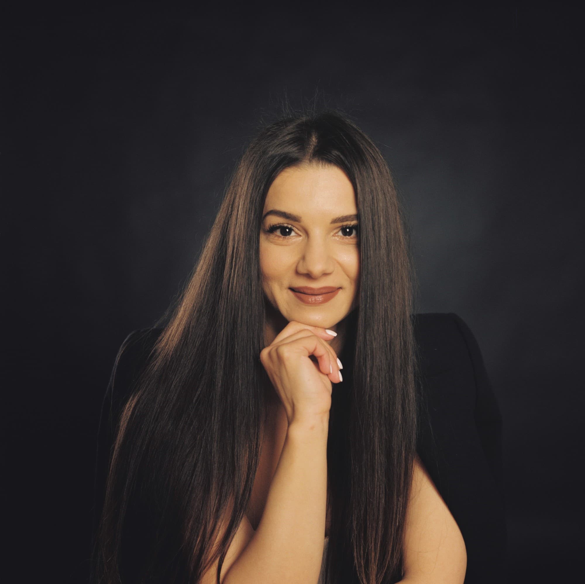Classic three light studio portrait of young woman holding her hand at her chin on Kodak Gold 200 color film.