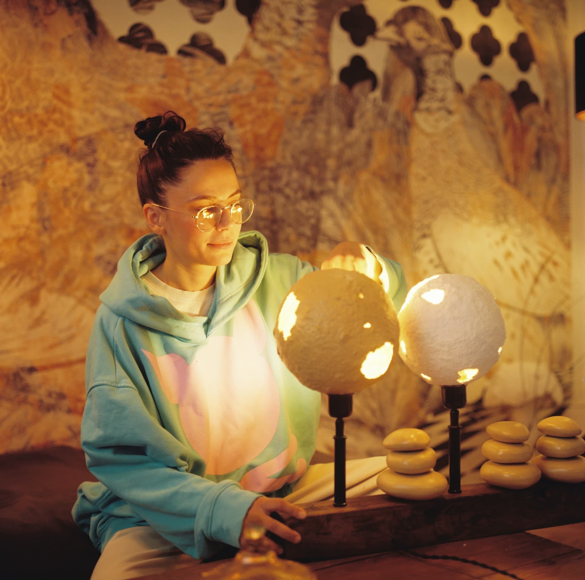 Warm color portrait of woman artist with desk lamp and patterned background on Kodak Gold 200 medium format film.
